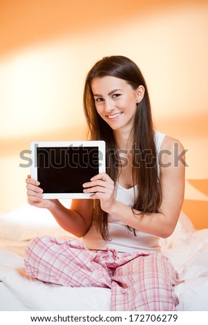 Gorgeous young brunette woman browsing with a tablet computer.