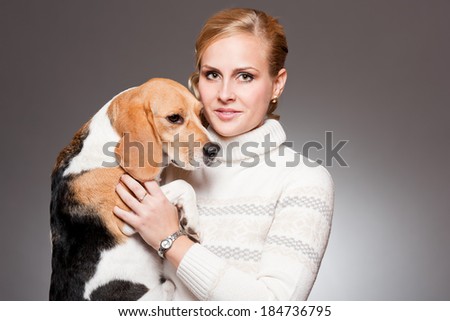 Portrait of a beautiful young blond woman with a cute beagle.