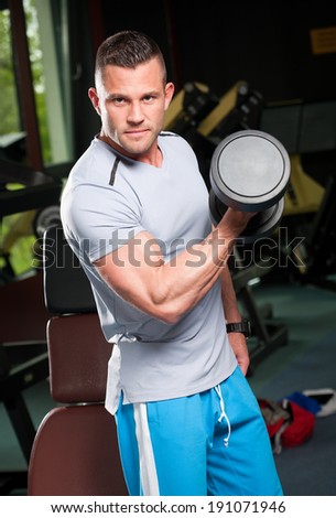 Attractive very fit young man working out in a gym.