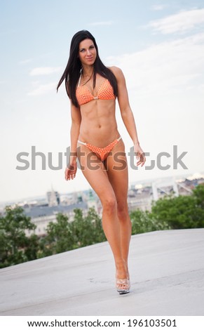 Portrait of a slender super fit young brunette woman.