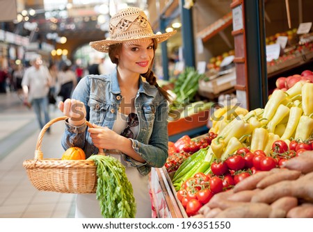Beautiful young brunette woman on a market getting fresh food.