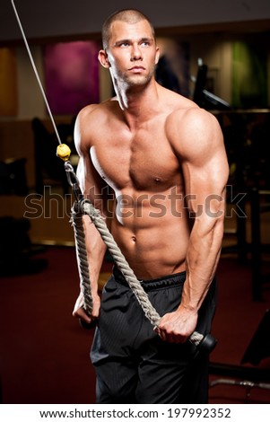 Portrait of a fit lean young man exercising in a gym.