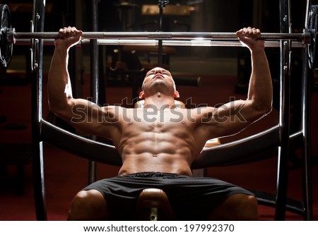 Portrait of a fit lean young man exercising in a gym.