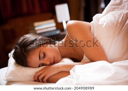 Gorgeous young brunette having a good night\'s sleep.