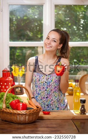Beautiful young brunette woman preparing healthy food in the kitchen.