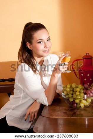 Portrait of a beautiful young brunette woman holding a glass of fine wine.