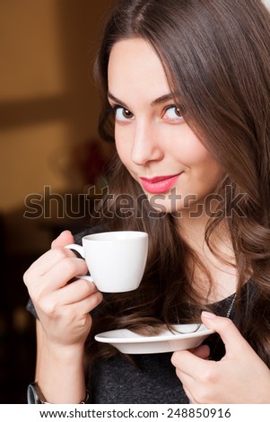 Portrait of a gorgeous young brunette woman having coffee.