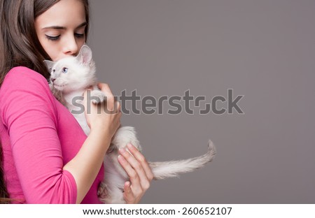 Portrait of a beautiful brunette holding a cute kitten.