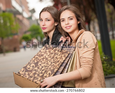 Couple of brunette beauties having shopping fun.
