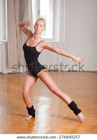 Gorgeous fit young blond woman practicing dance moves.