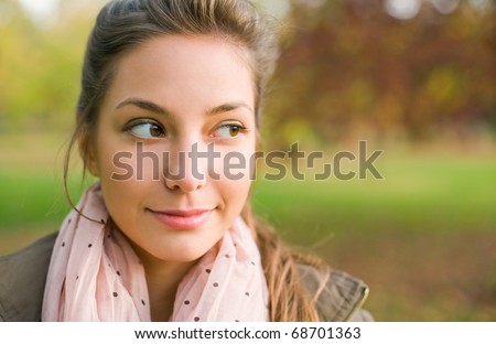 Portrait of beautiful young brunette taking a sideways glance, smiling.