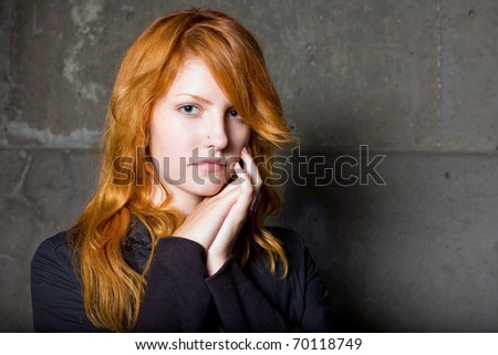 of a beautiful fashionable young redhead girl with sad facial expression