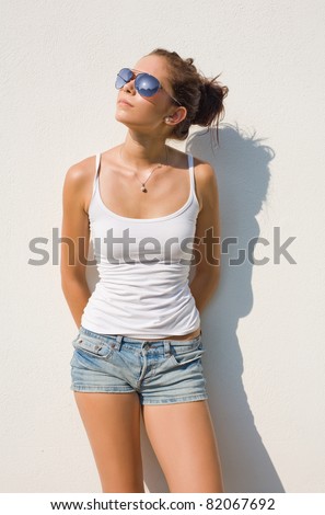 Beautiful young hot brunette posing in hot summer sunshine.