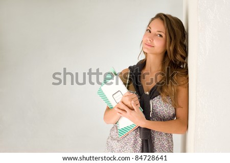 Beautiful relaxed young student girl with exercise books.