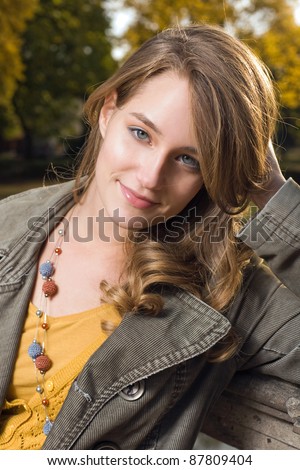 Beautiful young fashionable woman posing in autumn park.