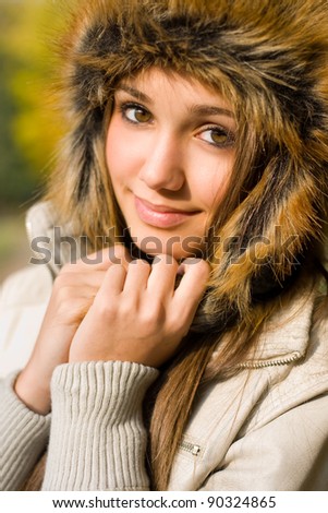 Gorgeous young brunette outdoors wearing russian style fur hat.
