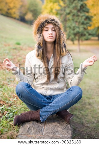 Beautiful funny young brunette model in fake meditation pose, mockery.