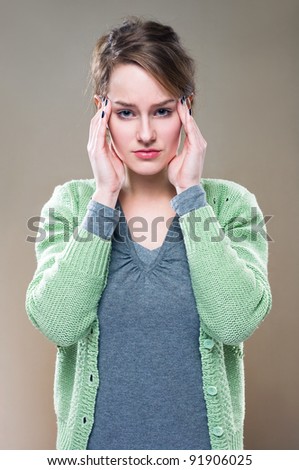 Half length portrait of a young brunette woman with terrible headache...