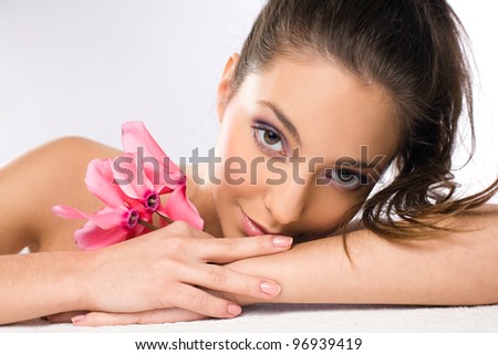 Portrait of a gorgeous relaxed spa girl with delicate pink flowers.