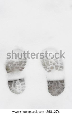 Hiking boot tracks in snow with white space for text