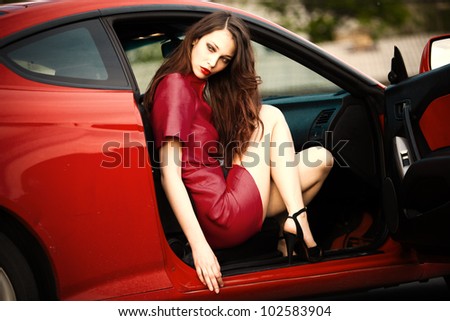 sensual stylish woman sit in red car