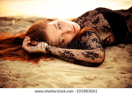 redhead beautiful woman on sand by the river