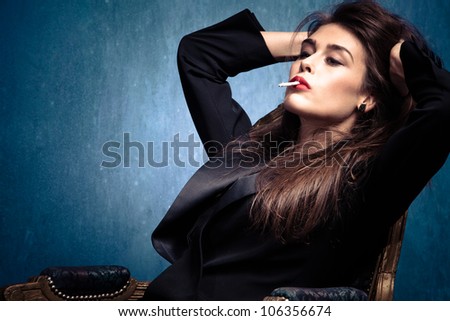 fashion elegant woman in black tuxedo with cigarette and hands in hair