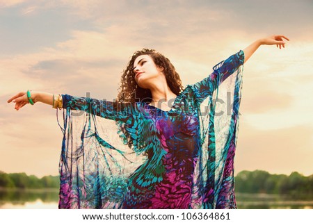 young woman in colorful dress dance in nature summer day small amount of grain added