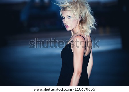 blond fashion model in  black dress and punk hairstyle outdoor shot at night