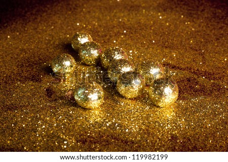 small sparkling golden balls in golden powder background