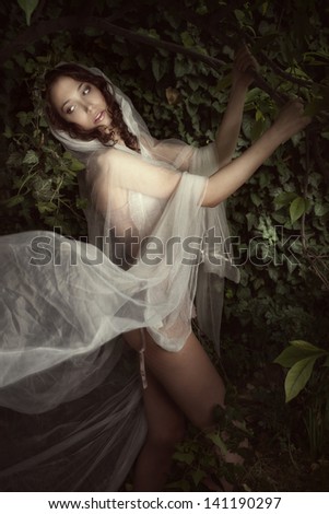 beautiful fantasy woman with white veil in forest