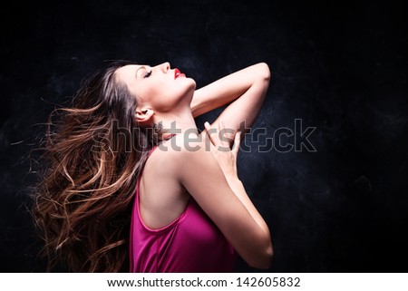 beautiful young woman portrait with long fluttering hair studio dark background