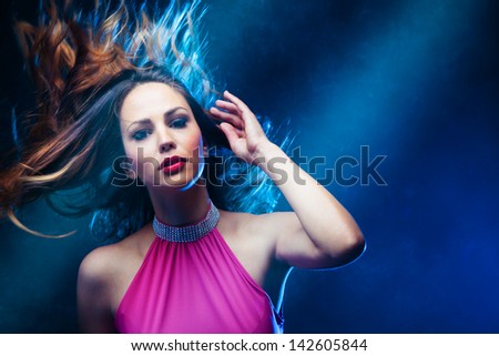 dancing woman in pink dress and  hair in motion   studio shot