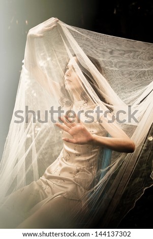 young woman in garden with veil cover her and sun light in front of her