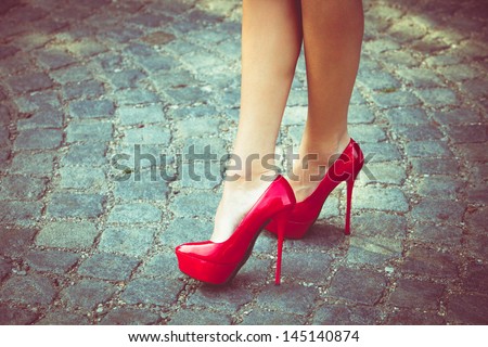 woman legs in red high heel shoes outdoor shot on  cobble street