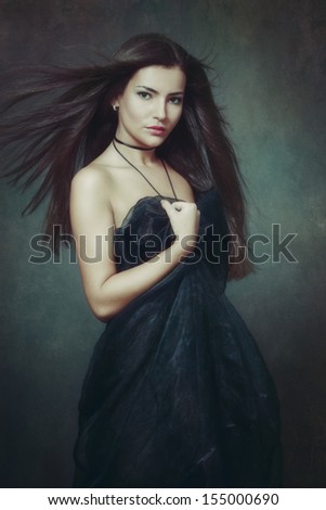 elegant woman with long fluttering hair portrait studio shot dark background
