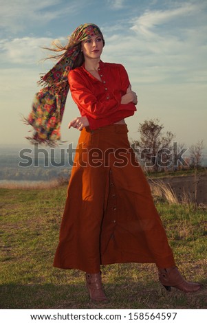 young blond woman in autumn fashion clothes,  red leather jacket, cashmere scarf and brown skirt outdoor shot