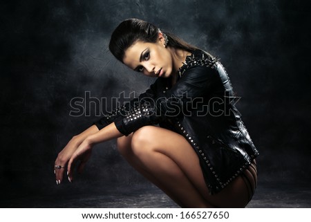 sexy brunette woman in black leather jacket  studio shot