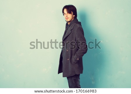 trendy young man in coat studio shot
