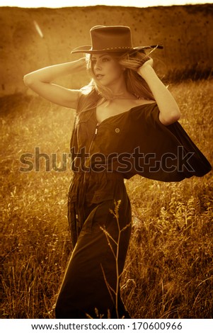 young woman in cowboy style clothes outdoor at sunset