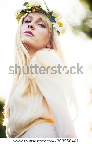 blonde beautiful young woman summer portrait with wreath of flowers in hair outdoor shot