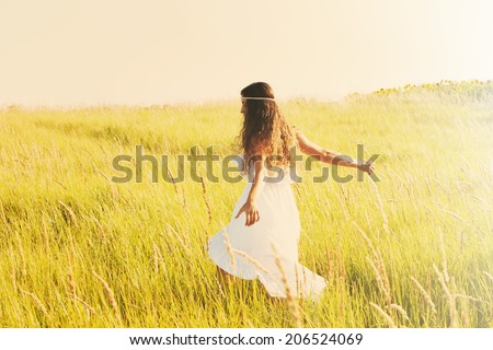 happy smiling woman in boho style clothes run  through the field, sunny summer day, retro colors