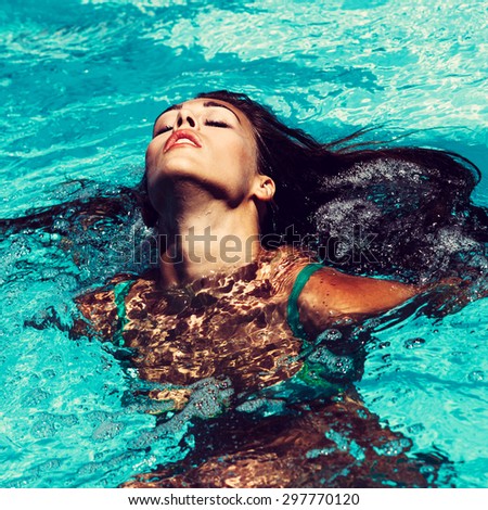 young attractive woman in  in pool with head thrown back
