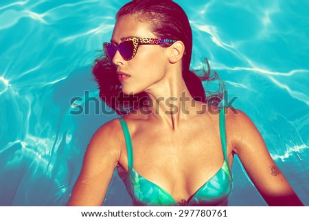 young attractive woman in  in pool with head thrown back above view