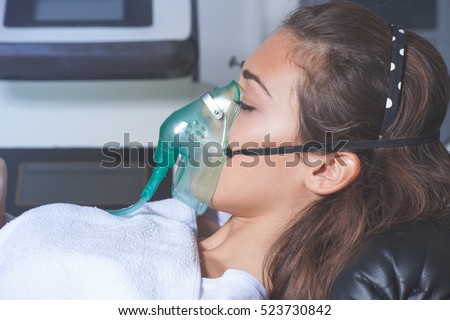 young woman with oxygen mask at hospital or cosmetics salon