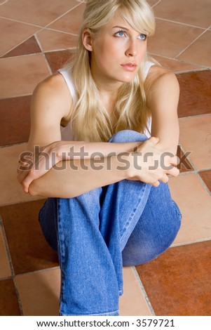 young woman sitting in empty room on mosaic floor