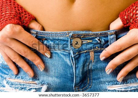 close up belly of young woman in blue jeans and red gloves