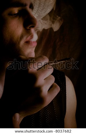 young man profile on dark background with cigarette