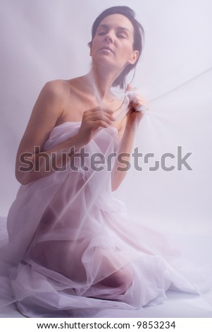 in a ballet pose with curtain in hand, studio shot