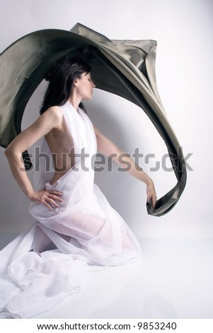 in a ballet pose with curtain in hand, studio shot